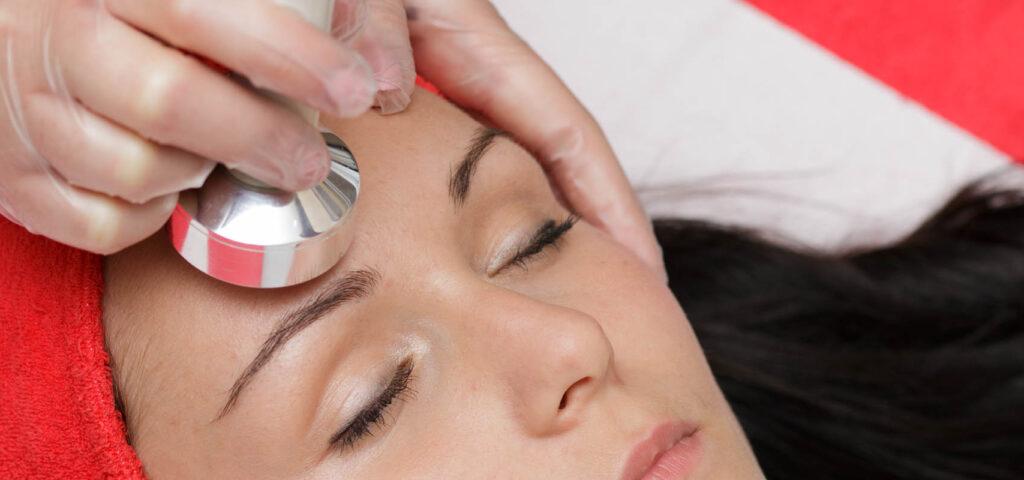 A device used in sonophoresis skincare treatment emitting ultrasonic waves for product absorption.
