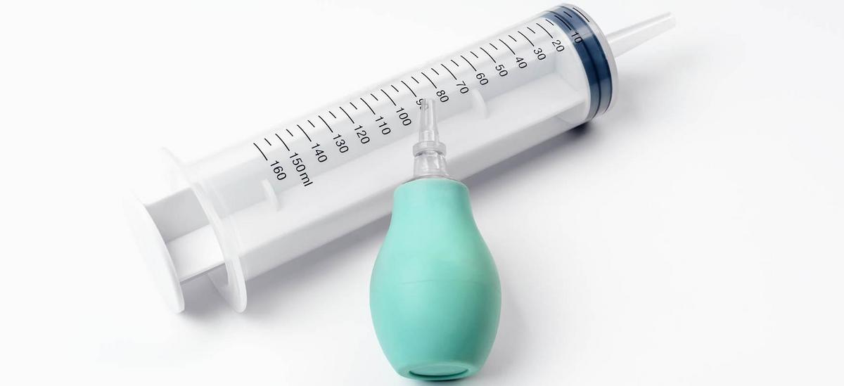 Person performing sinus rinse with a squeeze bottle for nasal irrigation and congestion relief.